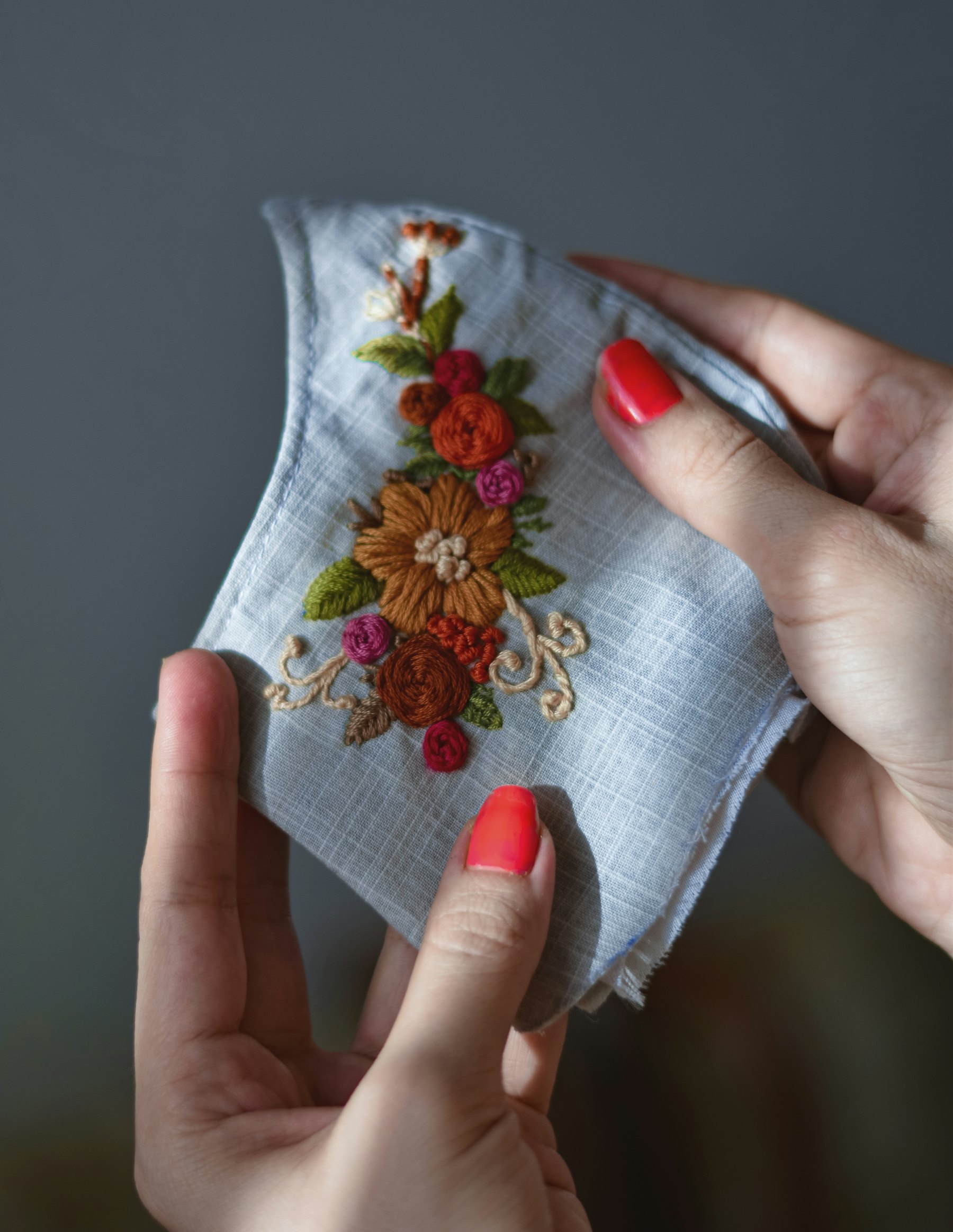A pair of hands holding embroidered cloth